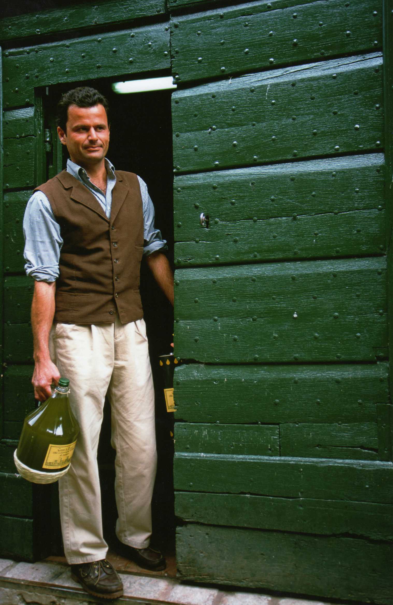 Luca Palombaro at the estate, carrying a demijohn of freshly pressed olive oil